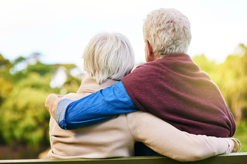 A shot from the back, senior couple sitting on a bench 